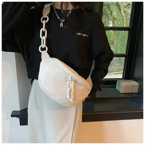 Detail of white PU leather crossbody bag with chunky chain strap and embossed lettering