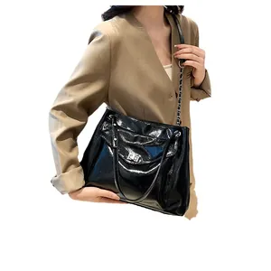 Glossy black leather tote bag with silver chain strap and metal twist lock for women