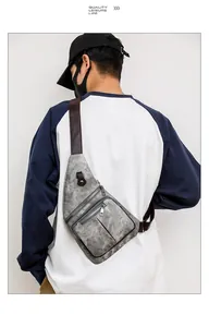 Vue détaillée d'un sac de poitrine gris avec plusieurs fermetures éclair et sangle en cuir