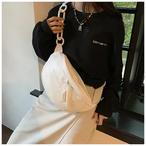 Detail of white PU crescent chest bag with chunky plastic chain and letter embossing