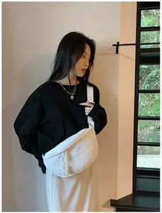 Detail showing the white PU shoulder bag with mystyleproper embossed text and wide strap