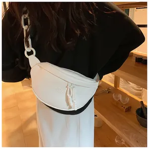 Close-up of white PU leather chest bag with embossed lettering and thick chain strap