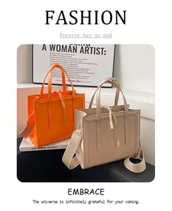 Detail of stylish leather tote bags in orange and beige with wide fabric straps