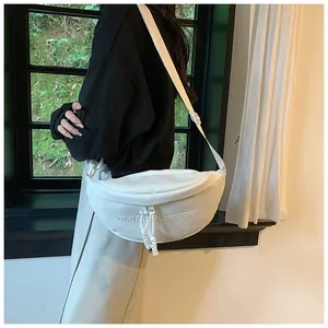 Detail of white PU leather crescent bag with embossed letters and knot zipper pull
