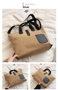 Detail view of khaki canvas tote bag featuring black leather buckle and front pocket design