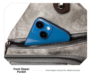 Détail de la poche zippée avant du sac bandoulière gris argenté avec espace téléphone