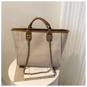 Gros plan détaillé d'un grand sac cabas en toile beige avec finitions en cuir marron