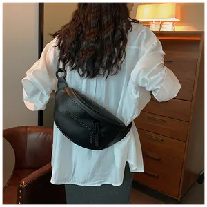 Close-up of black PU leather shoulder bag featuring embossed lettering and chain strap