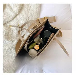 Detail view of the spacious beige crossbody bag interior filled with cosmetics