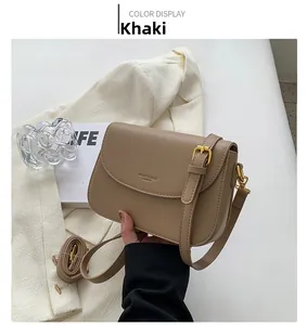Detail of khaki leather crossbody bag with adjustable strap and fashion lettering