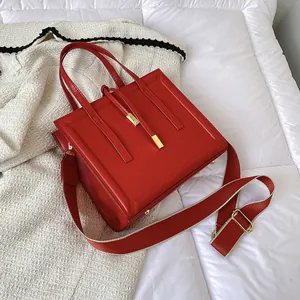 Fashionable red square leather crossbody handbag with golden hardware and wide strap