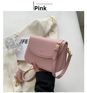 Pink minimalist crossbody bag with adjustable strap and polished golden hardware details