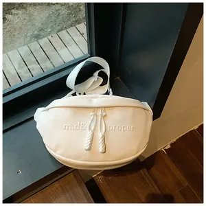 Detail of white PU leather bag featuring embossed letters and woven zipper pulls