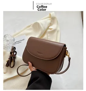 Detail view of coffee brown saddle bag with matte faux leather and metal buckle strap