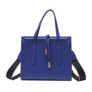 Navy blue rectangular shoulder bag with embossed border and stylish woven strap