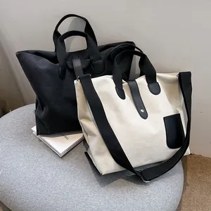 Minimalist large canvas tote bags in black and beige displayed with shoulder straps
