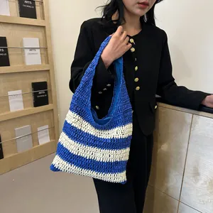 Blue and white striped woven straw tote bag with fabric lining for beach vacations