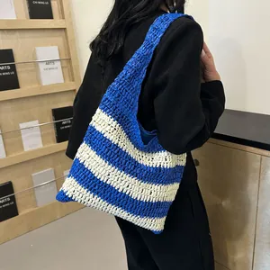 Detail of blue and beige striped straw tote bag with hollow woven texture for beach