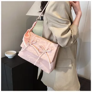 Détail du cabas rose avec nœud et foulard en soie imprimé cœur sur la bandoulière