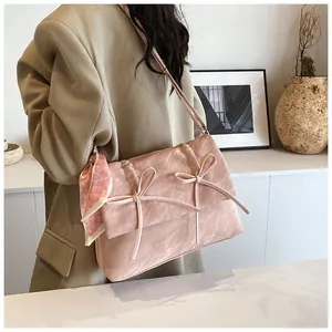 Détail du sac à main rose à nœuds en tissu plissé avec un foulard en soie à cœurs