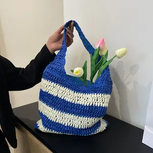 Detail of blue and white striped straw woven tote bag with a nautical holiday style