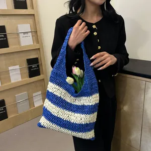 Close-up of blue and white striped straw tote with crochet texture and tulip floral details