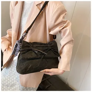 Sac bandoulière texturé noir avec nœud et détail de foulard à pois sur la sangle