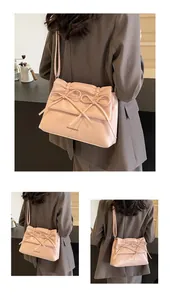 Detail view of pink shoulder bag featuring soft pleated leather and bowknot design