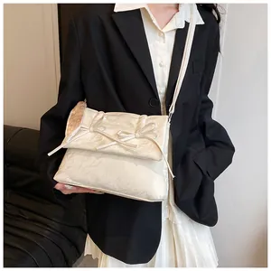 Détail du sac cabas matelassé crème avec nœuds et bandoulière à motifs de cœurs