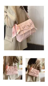 Détail du sac rose texturé avec nœuds et foulard en soie à imprimé cœur