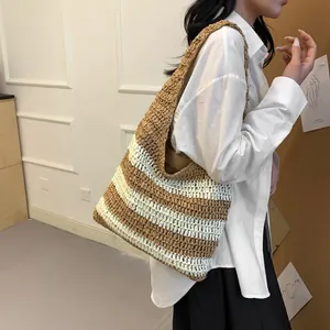 Detail of hand-woven straw shoulder bag with brown and beige stripes for summer travel