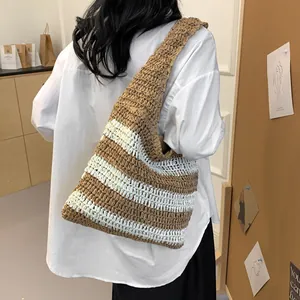 Detailed close-up of the woven texture and brown striped pattern on a large straw tote bag