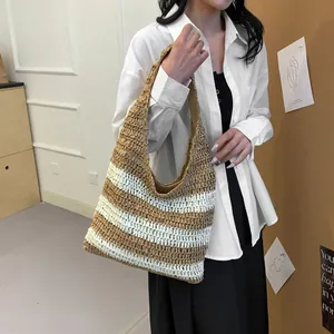 Detail of a large woven straw tote with brown and white stripes for beach vacations