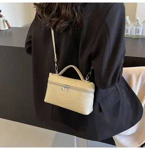 Dettaglio borsa beige in ecopelle coccodrillo con doppia cerniera argento e manico
