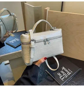 Dettaglio della texture a coccodrillo color crema sulla borsa a mano da donna