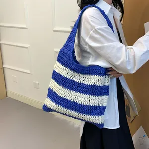 Detail of blue and white striped straw tote bag showing thick woven texture and large capacity