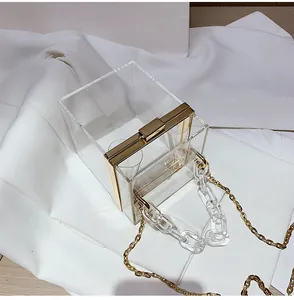 Macro shot of clear acrylic handbag with gold metal frame and thick chain detail