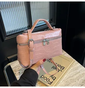 Dettaglio della borsa a scatola rosa con trama a coccodrillo, zip d'argento e tracolla