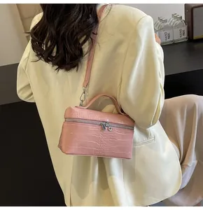 Dettaglio della borsa rosa con trama a coccodrillo, cerniere argento e tracolla regolabile
