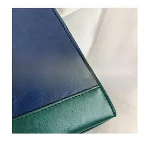 Détail de la couture contrastée sur cuir bleu et vert avec texture grainée