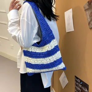 Detail view of the blue and white striped woven straw tote bag with crochet texture
