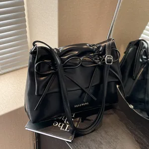 Chic black soft PU leather shoulder bag featuring a stylish bow and pleated details