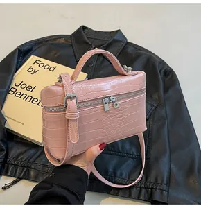 Dettaglio borsa a scatola rosa con stampa coccodrillo, finiture argento e doppia zip