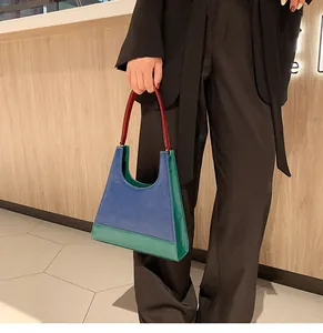Vue détaillée d'un sac à main trapèze en cuir avec panneaux vert et bleu marine