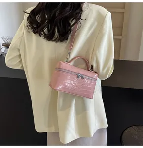 Vista dettagliata della borsa rosa con stampa coccodrillo e tracolla in pelle coordinata