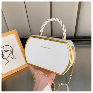 Detail einer weißen sechseckigen Handtasche mit Goldrand und gedrehtem Griff