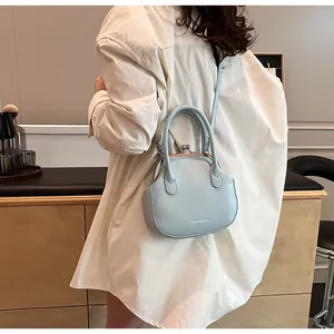Detail of light blue vintage shell bag with metal clasp and matte leather texture
