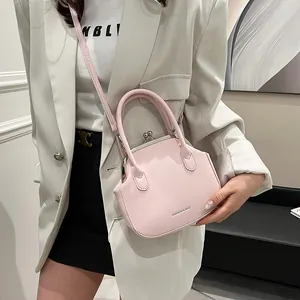 Pink minimalist shell-shaped handbag with classic metal clasp and detachable strap