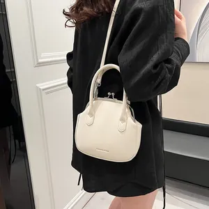 Chic off-white shell handbag with metal kiss-lock and adjustable strap in crossbody style