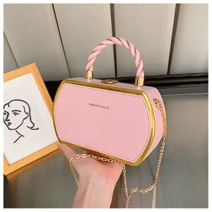 Detailansicht der rosa Box-Handtasche mit goldenem Metallrahmen und Kettenriemen